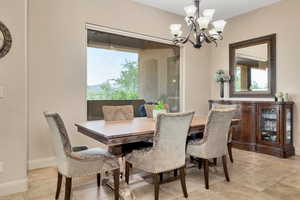Dining area featuring a chandelier, healthy amount of natural light, and light tile patterned floors
