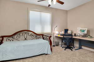 Bedroom featuring an office area, carpet floors, and a ceiling fan
