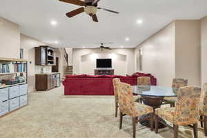 Dining room featuring light colored carpet, a ceiling fan, and recessed lighting