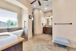 Bathroom featuring vanity, a ceiling fan, a soaking tub, and recessed lighting