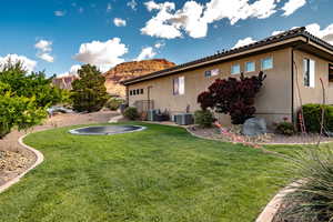 Back of house featuring a lawn, stucco siding, and a patio area