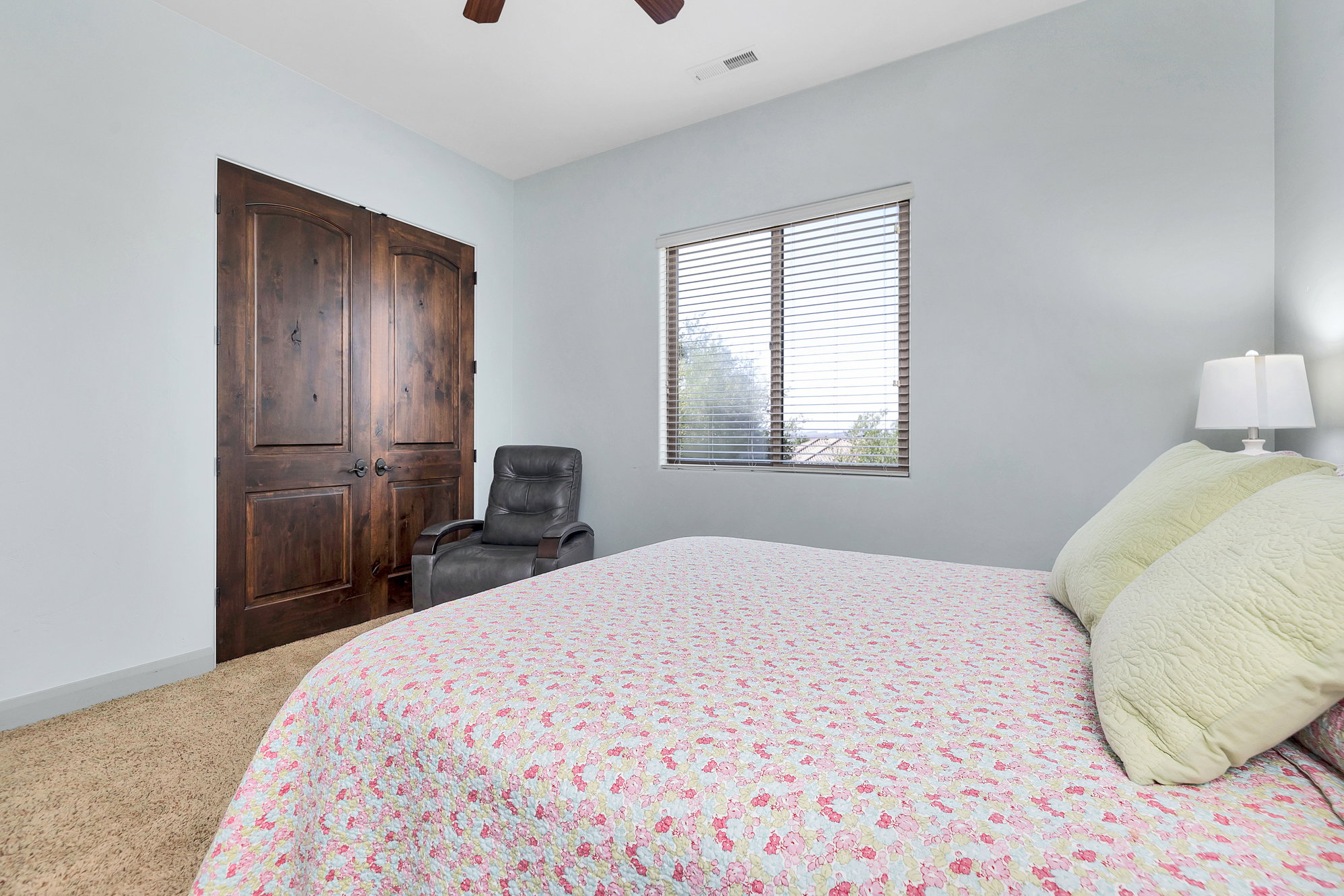 Bedroom with light carpet, a closet, and a ceiling fan