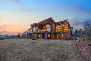 Rear view of house featuring a patio, a balcony, a yard, and a mountain view