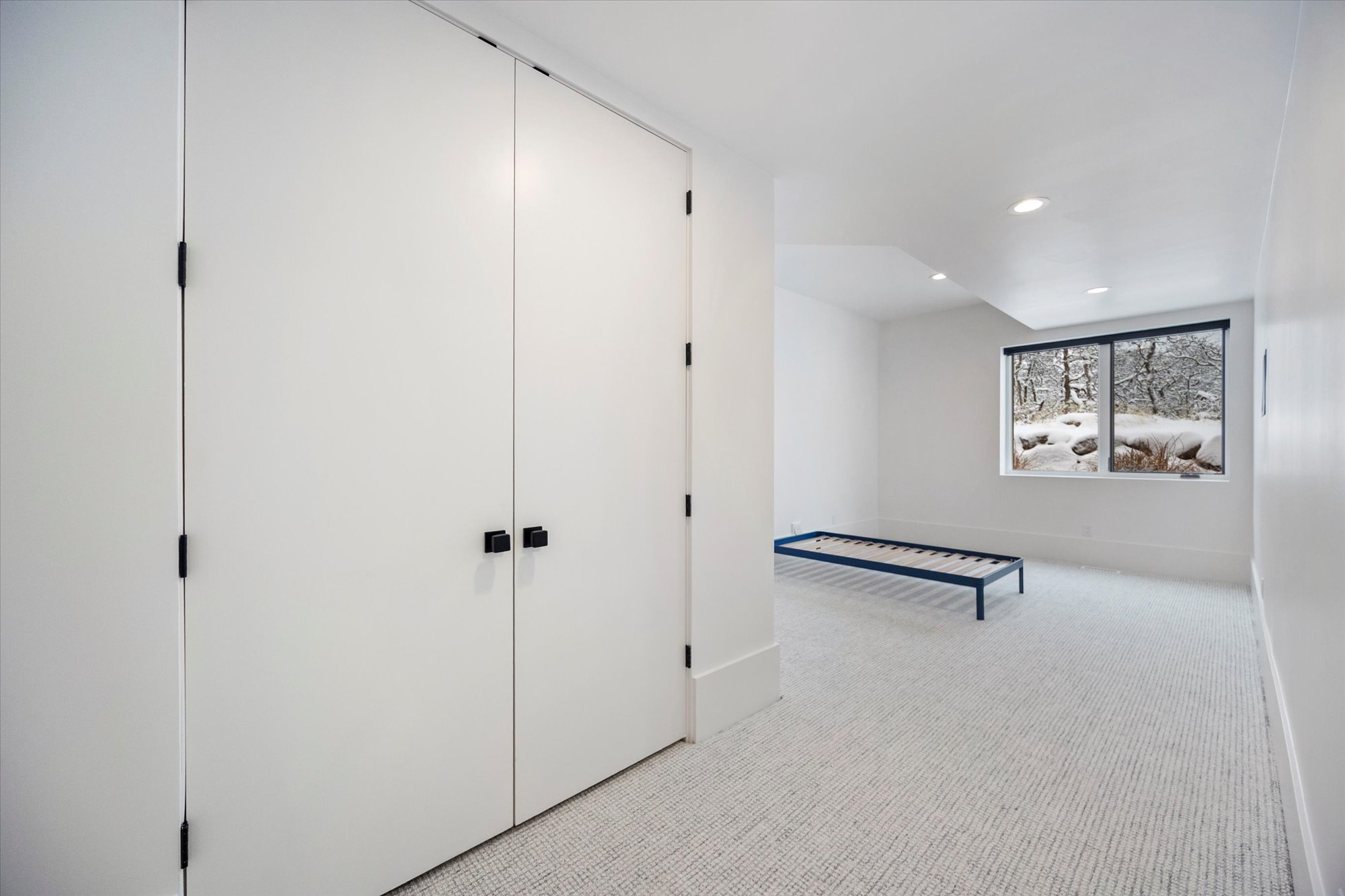 Unfurnished bedroom featuring light carpet, recessed lighting, and a closet