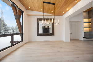 Unfurnished dining area with light wood finished floors, plenty of natural light, a vaulted wood ceiling, and recessed lighting