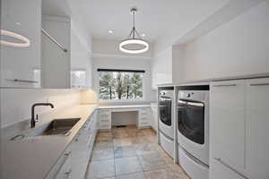 Laundry room featuring washer and clothes dryer, recessed lighting, and cabinet space