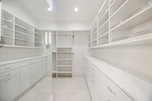 Walk in closet with light colored carpet