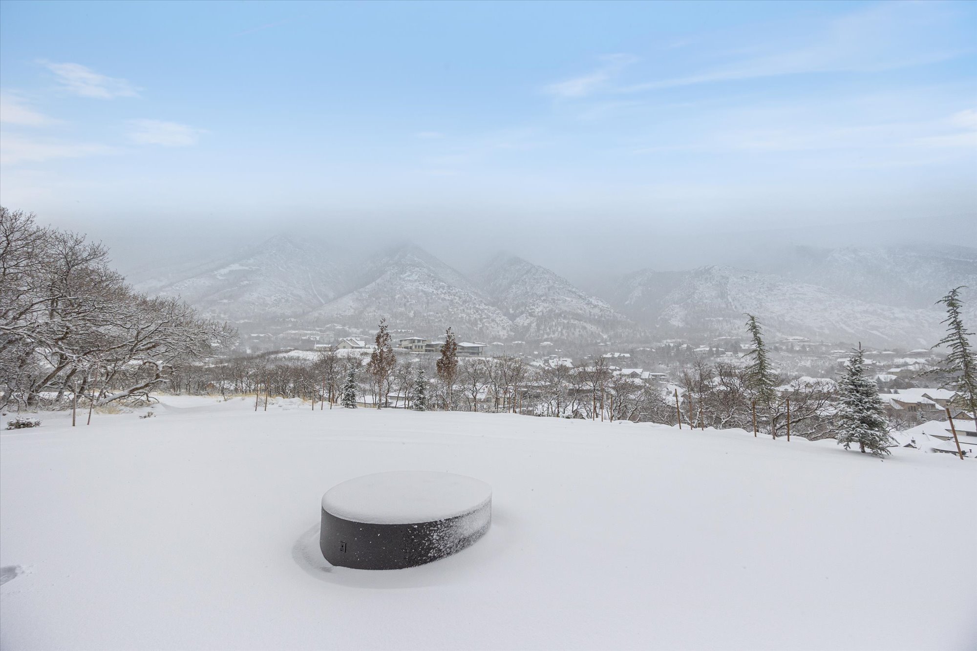 Yard covered in snow with a mountain view