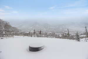 Yard covered in snow with a mountain view