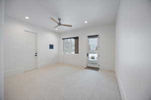 Empty room featuring light colored carpet, a ceiling fan, and recessed lighting