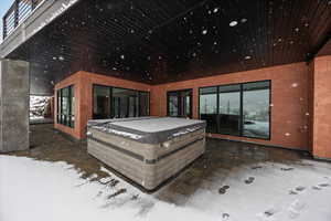 Wooden terrace with a hot tub and a patio area