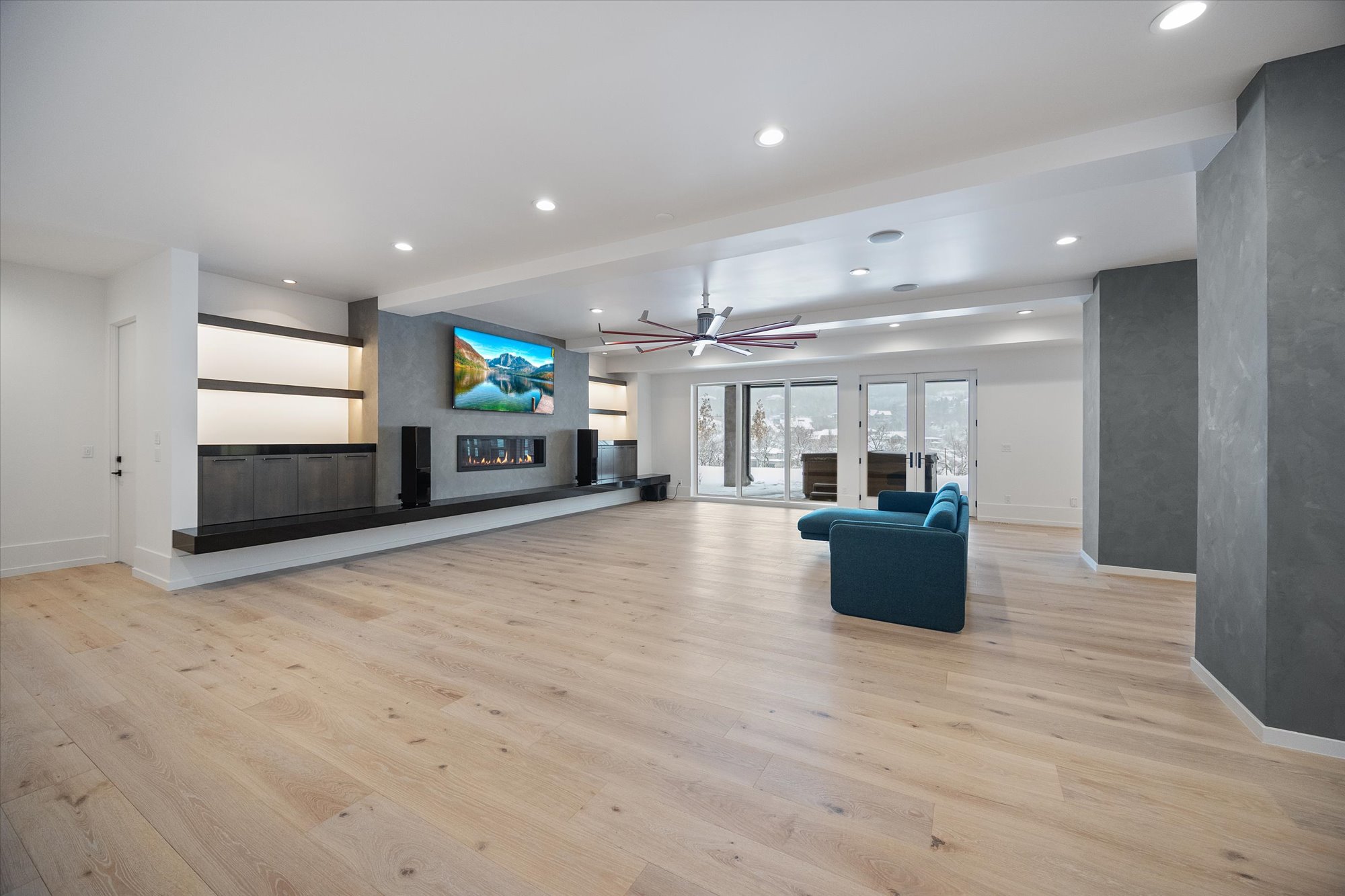 Unfurnished living room featuring recessed lighting, light wood-type flooring, ceiling fan, and a glass covered fireplace
