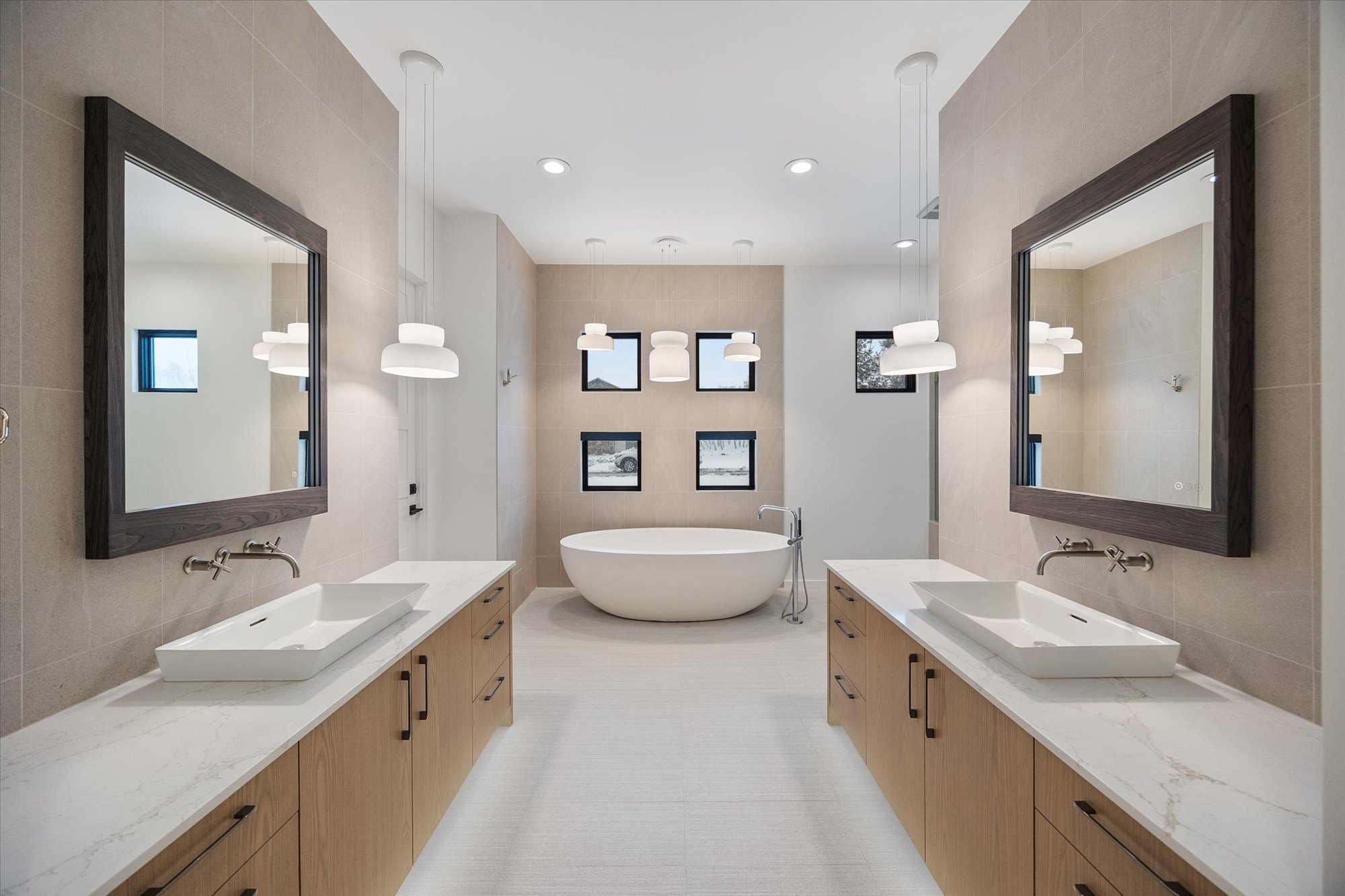 Full bath with tile walls, decorative backsplash, two vanities, a soaking tub, and recessed lighting