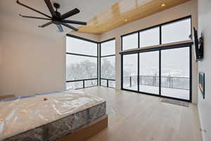 Bedroom with light wood finished floors, multiple windows, ceiling fan, access to exterior, and recessed lighting