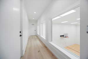 Hall featuring light wood-type flooring and recessed lighting