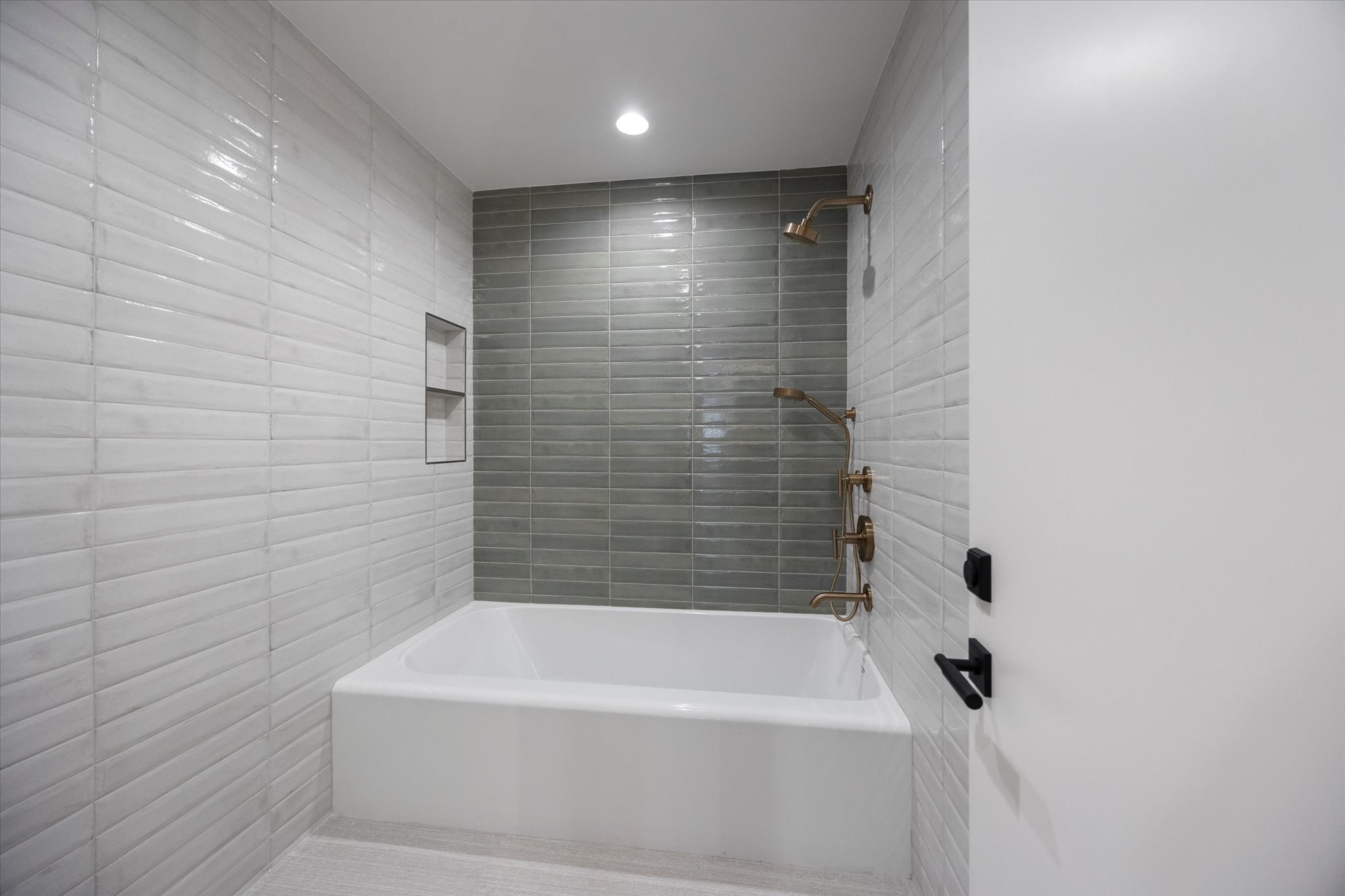 Bathroom featuring  shower combination, recessed lighting, and tile walls
