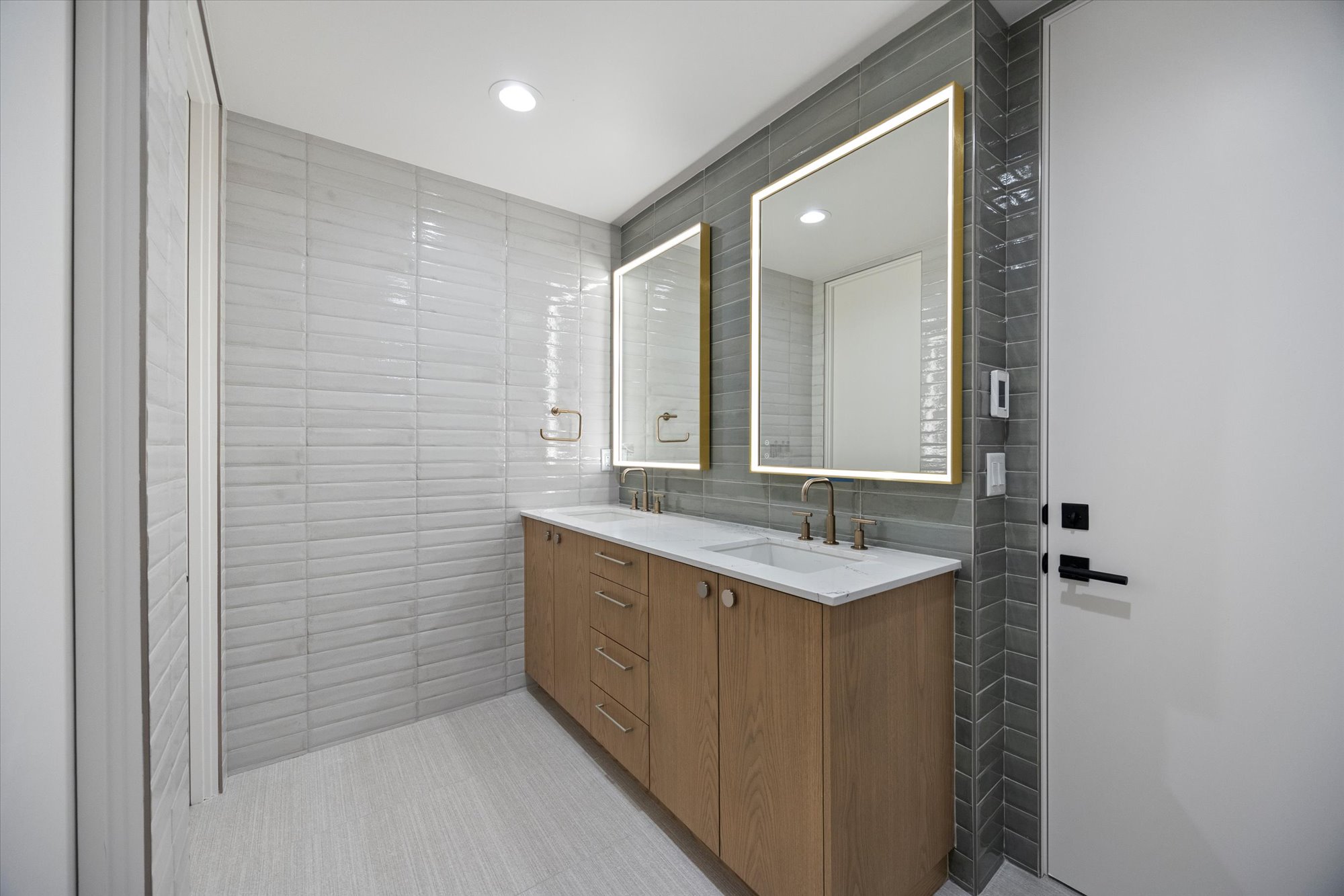Bathroom featuring tile walls, double vanity, and recessed lighting