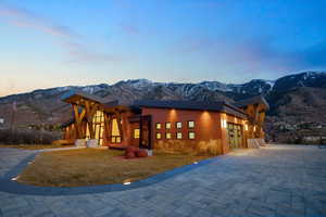 Modern home featuring a mountain view, driveway, a yard, a garage, and stucco siding