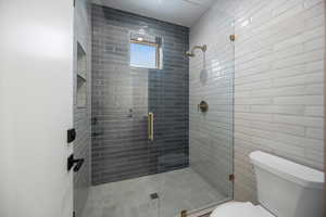 Full bathroom featuring toilet and a stall shower