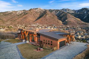 Contemporary house with a mountain view, a metal roof, an attached garage, decorative driveway, and stucco siding