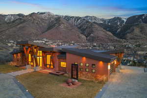 Modern home featuring a mountain view, a front lawn, driveway, and a garage