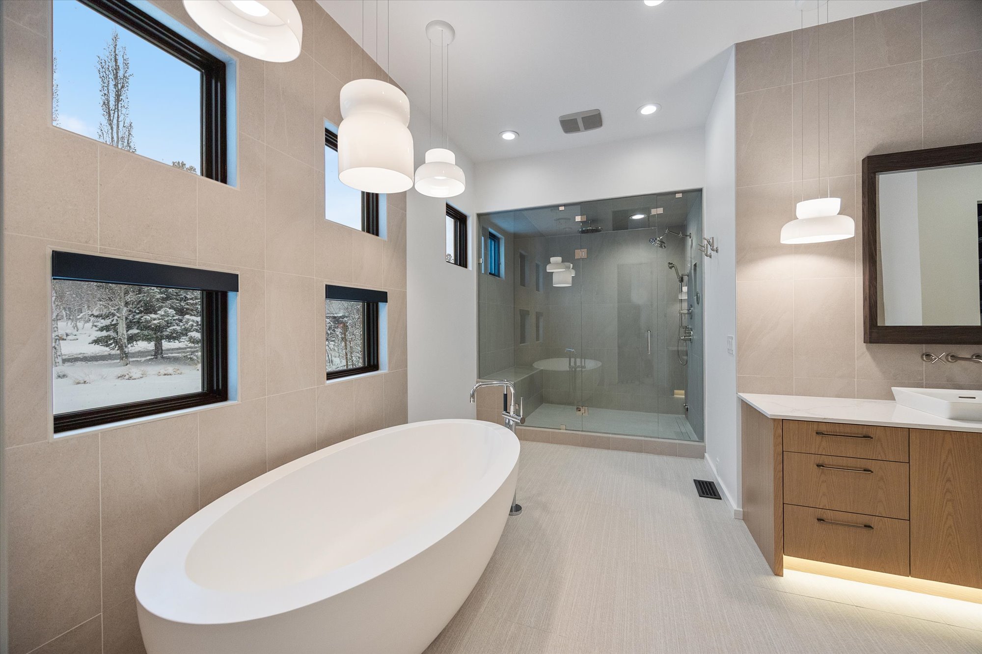 Full bath with tile walls, a soaking tub, a shower stall, vanity, and recessed lighting