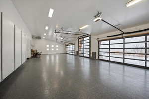 Garage featuring a garage door opener and a heating unit