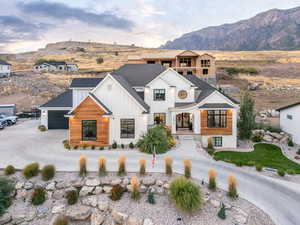 View of front of house featuring curved driveway, a shingled roof, board and batten siding, a mountain view, and an attached garage