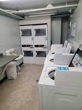 Shared laundry room with stacked washer / drying machine and washer and clothes dryer