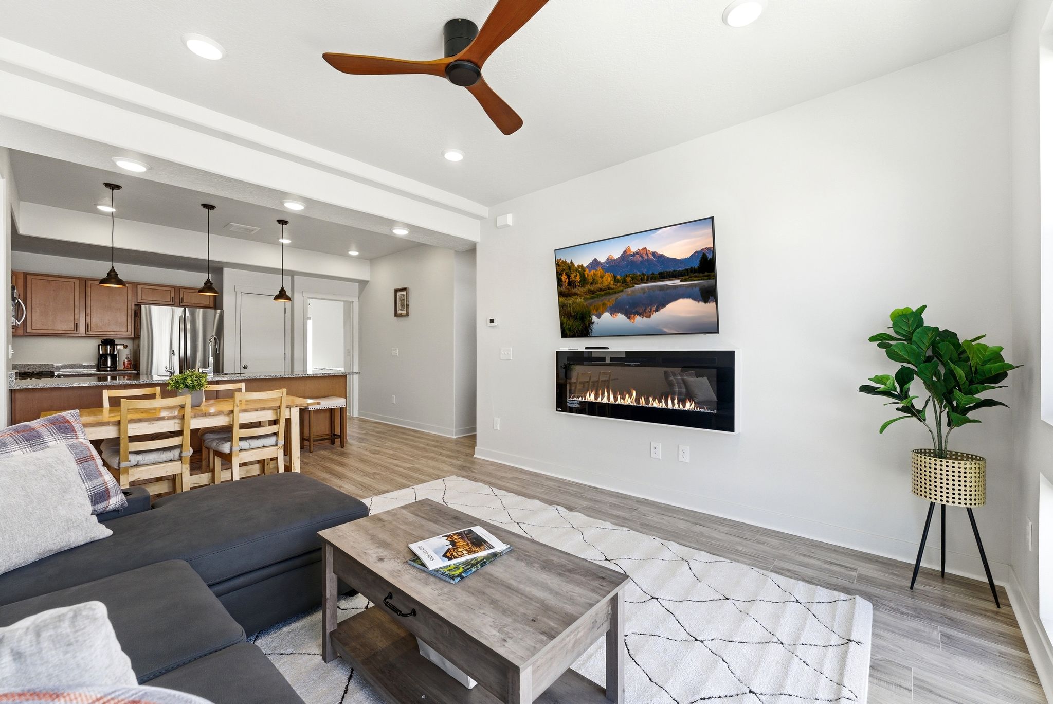 Living area featuring a ceiling fan, light wood finished floors, recessed lighting, and a glass covered fireplace
