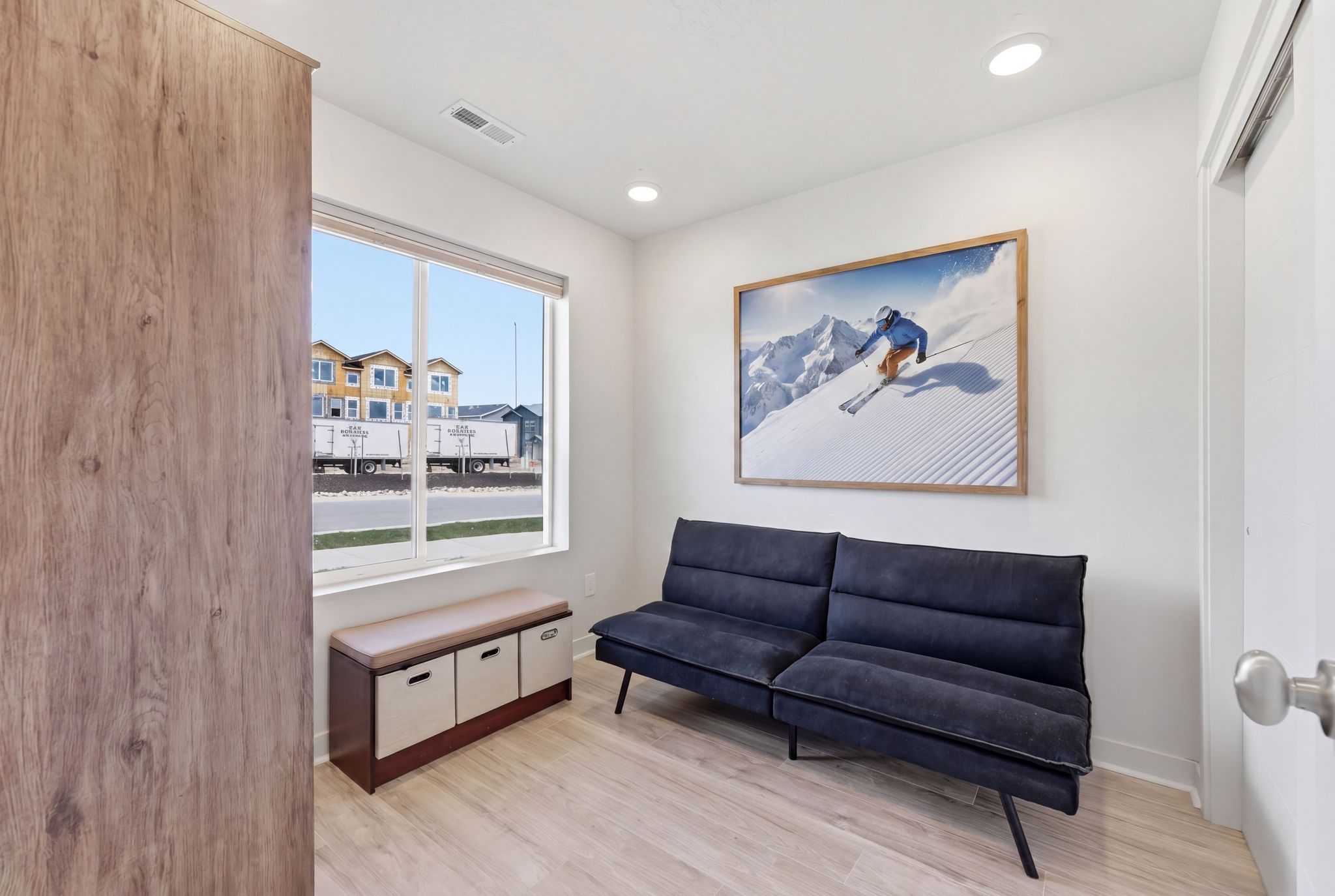 Living area with light wood-style floors and recessed lighting
