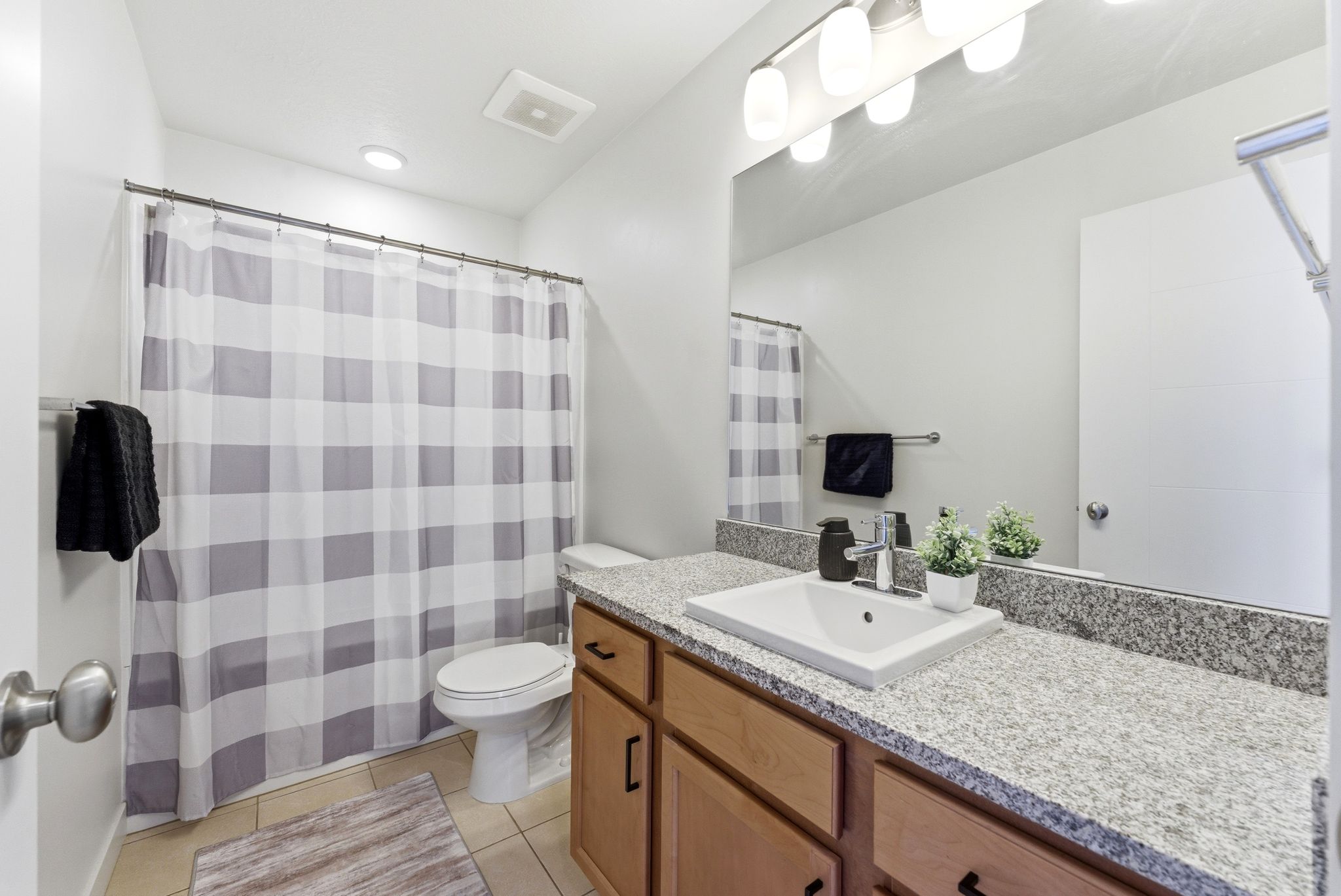 Full bath featuring vanity, a shower with curtain, and light tile patterned floors