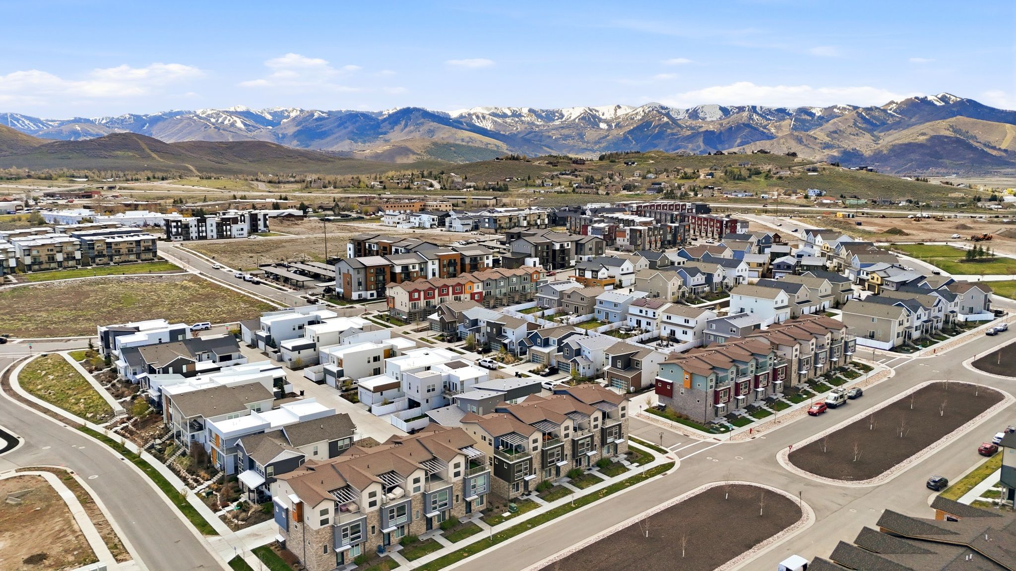 Aerial view of property and surrounding area featuring mountains and nearby suburban area