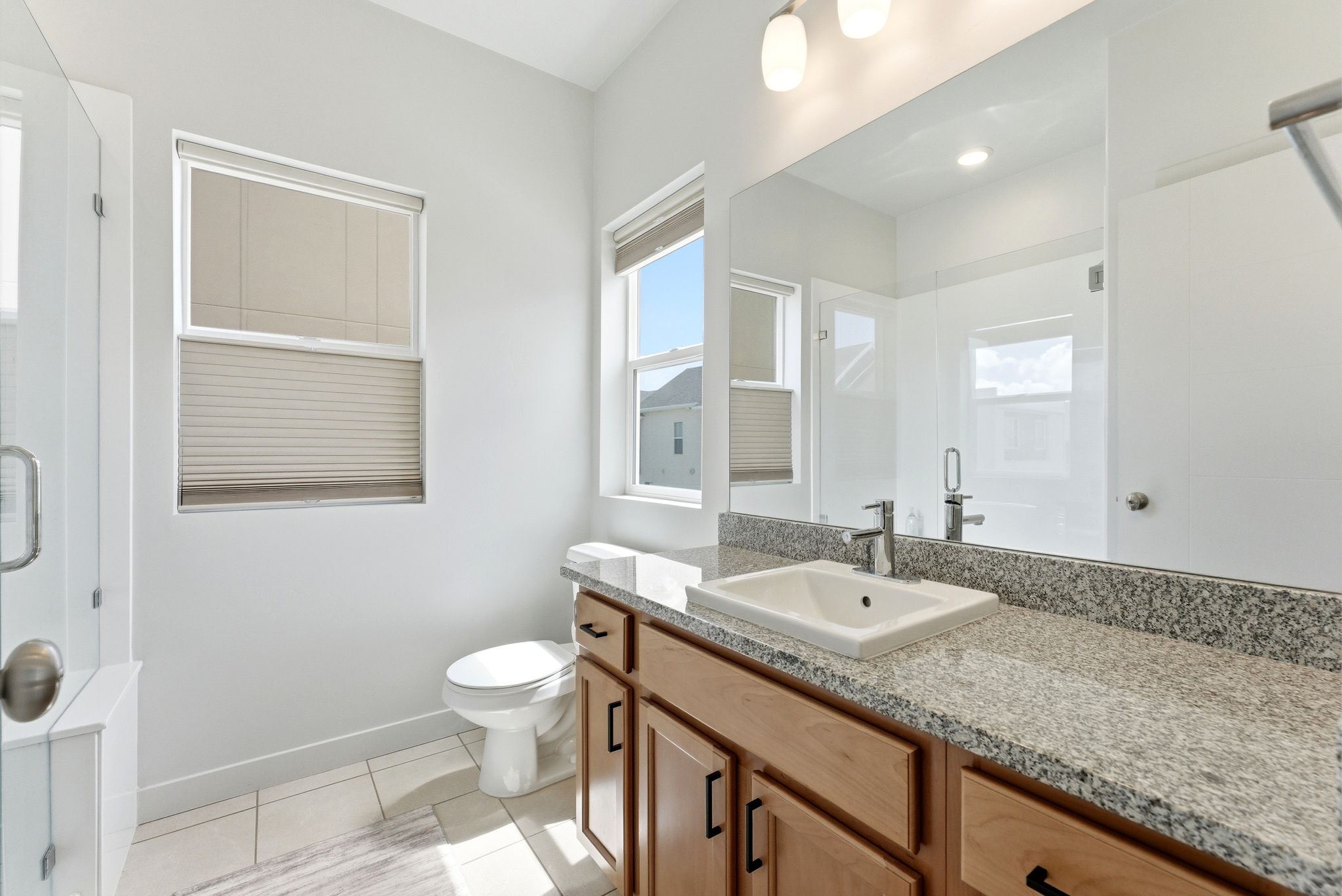Bathroom featuring vanity, a stall shower, and light tile patterned floors