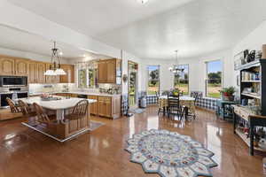 Kitchen featuring light countertops, a kitchen island, stainless steel appliances, a textured ceiling, and a breakfast bar