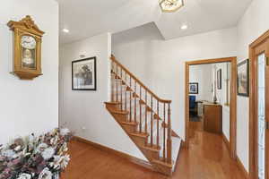 Staircase featuring wood finished floors, a textured ceiling, and recessed lighting