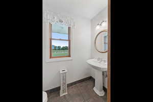 Bathroom with toilet and dark tile patterned flooring
