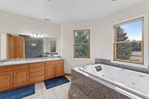 Bathroom with double vanity, tiled shower, light tile patterned flooring, and a whirlpool tub