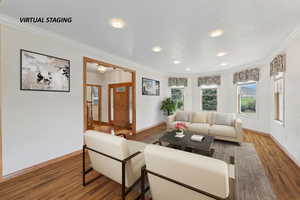 Living area with crown molding and wood finished floors