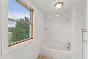 Full bathroom featuring bathing tub / shower combination and light wood-type flooring