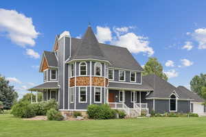 Back of property with a porch, a yard, roof with shingles, and a chimney