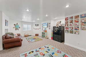 Playroom with light carpet and a textured ceiling