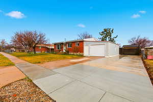 Ranch-style house with concrete driveway, brick siding, and a garage