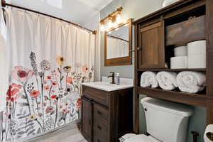 Bathroom with vanity, a shower with shower curtain, and light wood-type flooring