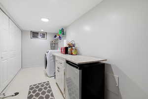 Laundry room featuring light floors, separate washer and dryer, recessed lighting, and cabinet space