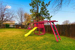 View of play area with a fenced backyard