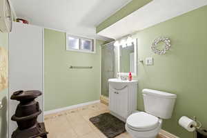 Bathroom with vanity, light tile patterned floors, and a stall shower