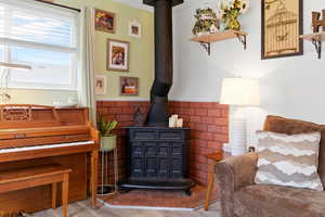 Living area with wainscoting, a wood stove, and light wood finished floors