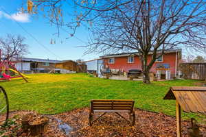 Fenced backyard with a playground, a patio area, and an outdoor hangout area