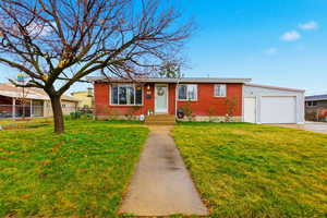 Ranch-style house featuring an attached garage, brick siding, and driveway